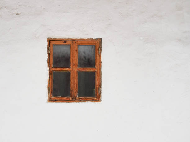 istock Old wooden window on a white wall background. Rural 907570836