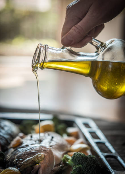 Fresh dorado fish with fruits and vegetables. Hand putting olive oil