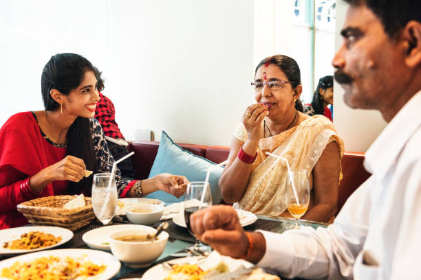 familia que tiene la comida de la india - comida hindú fotos fotografías e imágenes de stock