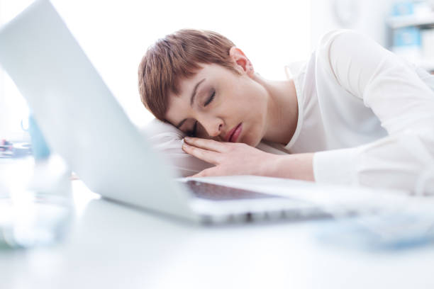 istock Tired businesswoman sleeping on her desk 907583296