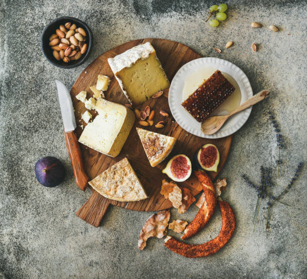 istock Flat-lay of cheese assortment, figs, honey, bread and nuts 907591082
