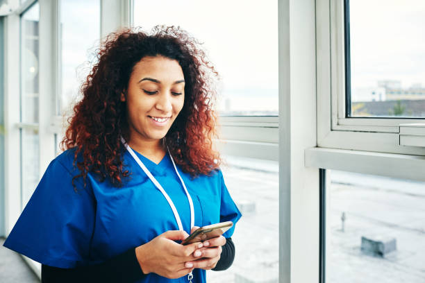 istock Smiling female doctor using cell phone 907591254