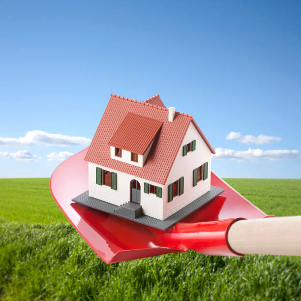istock Build A House. Miniature Model House On Shovel. 907591338