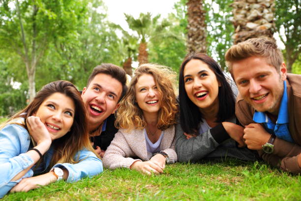 istock happy young friends lying in the park 907591402