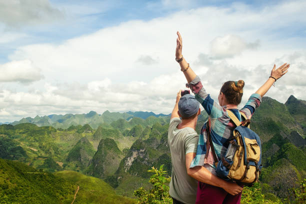 couple of tourists making selfie on background of karst mountains. stock photo