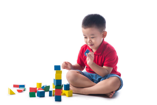 Asian little boy playing with colorful blocks, isolated on white background