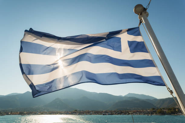 istock Greece Flag waving on blue sky background 907605238