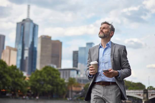 istock Thoughtful executive with coffee cup and phone 907610644