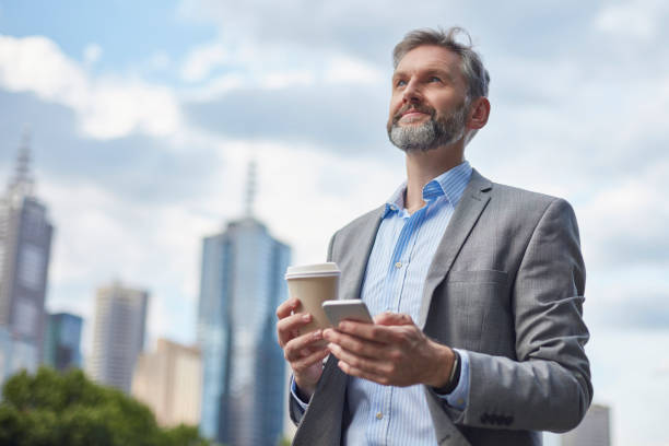 istock Businessman holding phone and coffee cup 907610766
