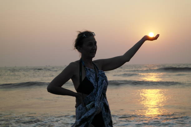 Girl and sun The beautiful girl holds the sun falling in the sea in palms religion sunbeam one person children only stock pictures, royalty-free photos & images