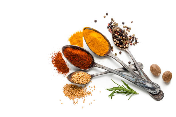 istock Spices and herbs in old spoons isolated on white background 907613740
