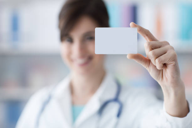 istock Doctor holding a business card 907614262