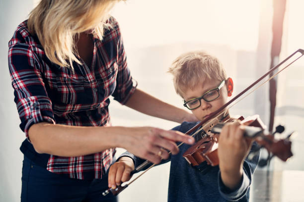 niño aprendiendo a tocar violín. - violin family fotografías e imágenes de stock