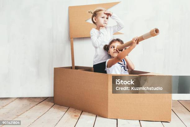 Zwei Kinder Spielen Kleine Mädchen Nach Hause In Einem Karton Schiff Kapitäne Und Matrosen Stockfoto und mehr Bilder von Kind