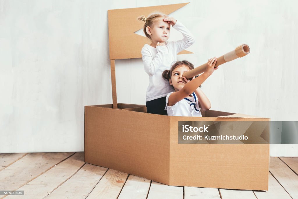 Dos niños niñas en una nave de cartón jugar capitanes y marineros - Foto de stock de Niño libre de derechos