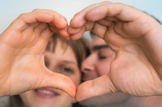 istock Couple making heart shape with hands and looking through it 907626318