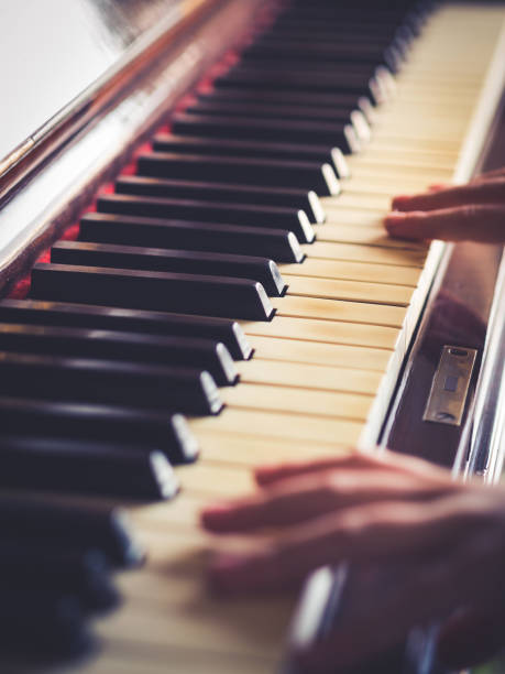 istock Vintage piano keys and hands playing 907630338