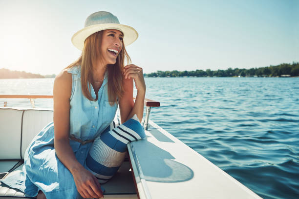 Experiencing the open sea in luxury Shot of an attractive young woman spending the day on her private yacht summer stock pictures, royalty-free photos & images