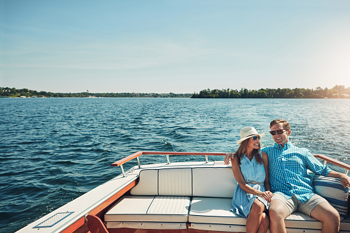 Shot of a young couple spending time together on a yacht