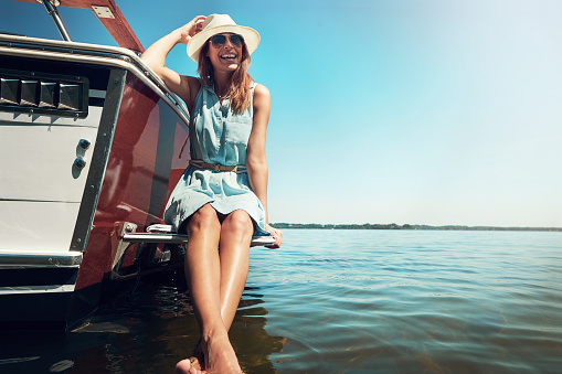 Shot of an attractive young woman spending the day on her private yacht