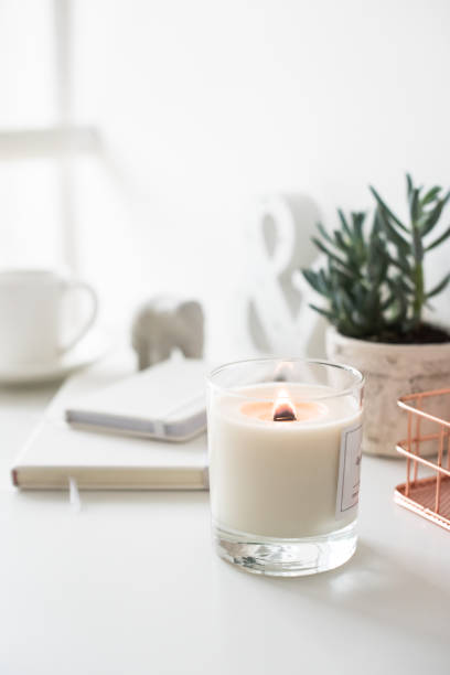 istock White burning candle on table, home interior decorations 907639300