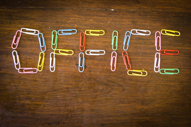 bored at the office knolling concept: single word 'office' made with paper clips on desk - escaping the rat race imagens e fotografias de stock