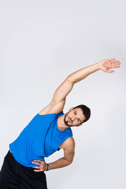 istock sportive young man doing side bend isolated on white 907645128