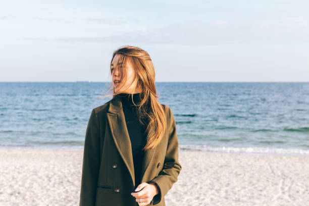 istock Beautiful young woman in a green coat 907648872
