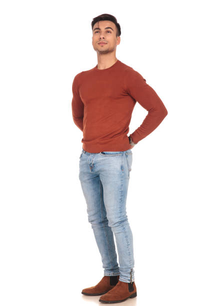 istock man standing with hands at his back and looks up 907648878