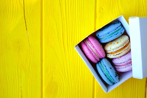 french multi tastes macarons buiscits whith flowers on wooden background - close up cookie gourmet food imagens e fotografias de stock