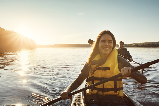 Shot of a young couple kayaking on a lake outdoors