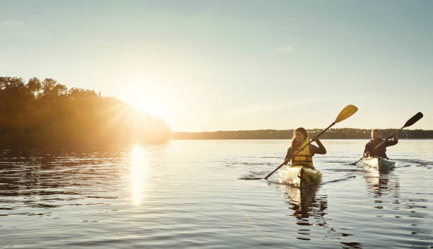 crea ricordi sull'acqua - men sitting canoe canoeing foto e immagini stock