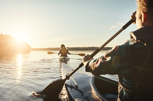 Shot of a young couple kayaking on a lake outdoors