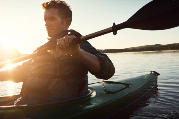 remare verso la felicità - men sitting canoe canoeing foto e immagini stock