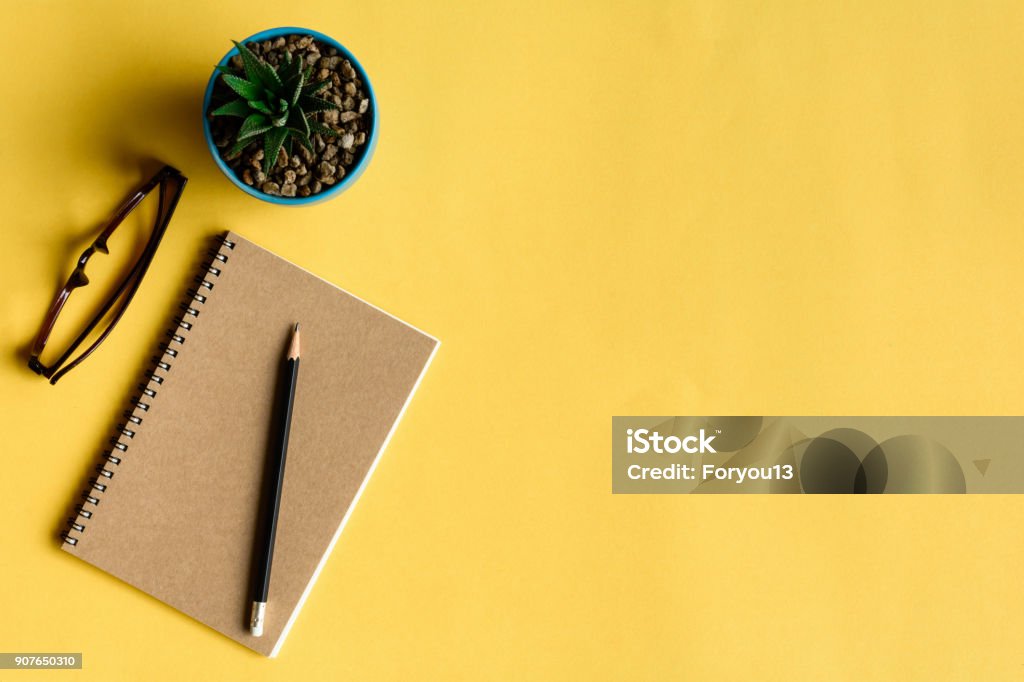 блокнот и карандаш на желтом столе - Стоковые фото Блокнот роялти-фри