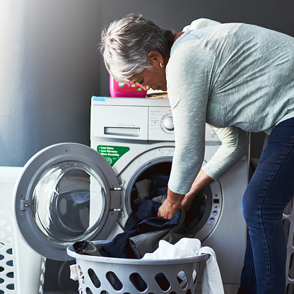 Shot of a mature woman doing laundry at home