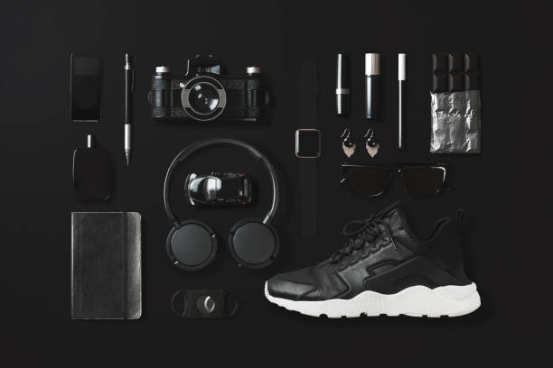 Black fashion and technology items flat lay on black background