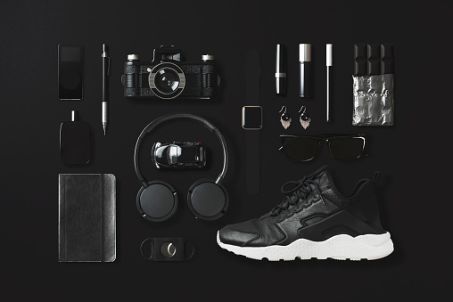 Black fashion and technology items on black background