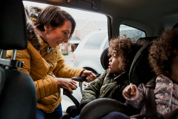 istock Putting Child Into Car Seat 907657716