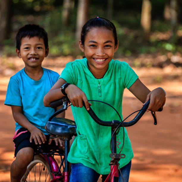 istock Cambodian children riding bicycle, Cambodia 907662940