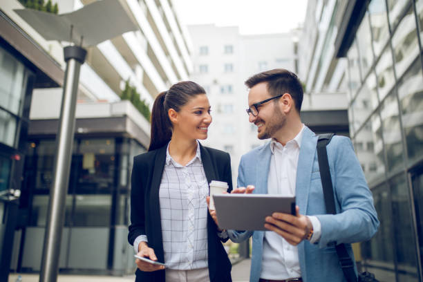 istock Business team discussing business project using tablet outdoors 907665916