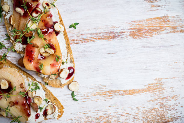 istock Bread with ricotta cheese and pears on the wooden background 907670686