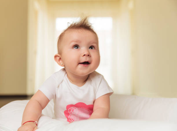 istock curious little baby girl is looking up 907670698