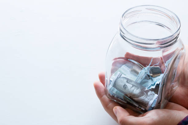 istock man holds a glass jar for donations with place for text on a white background 907671150