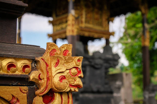 Temple details in Bali in Balinese Village showing traditional craftsmanship of local cultures, taken in public shrine in small Balinese village Siedemen. Wood carved gilded details on shrine