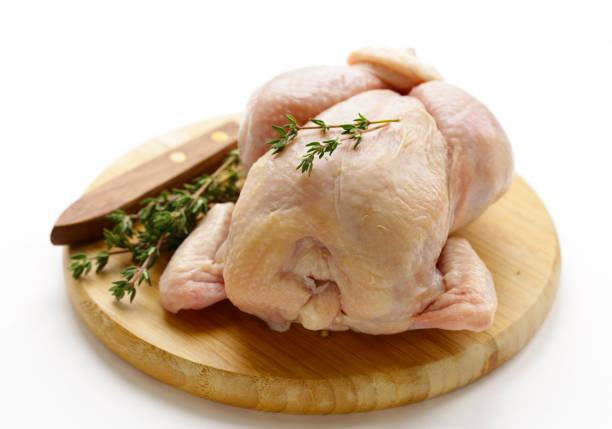 istock raw chicken with herbs and spices on a wooden board 907676044