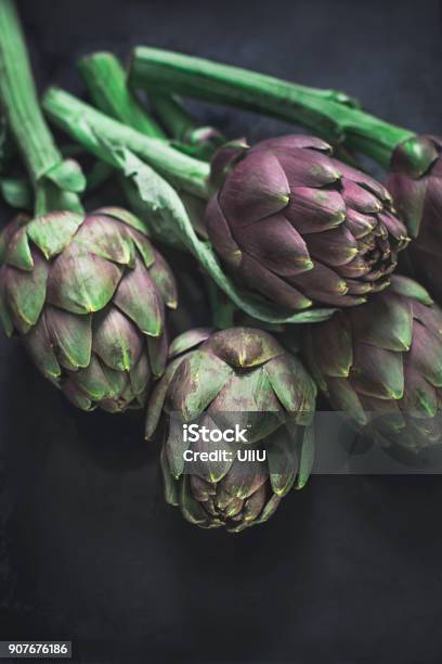 Roman Fresh Artichokes On A Dark Background Stock Photo - Download Image Now - Agriculture, Artichoke, Backgrounds