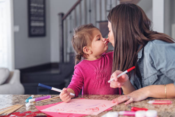istock Valentine's Day, mother making valentine cards 907676220