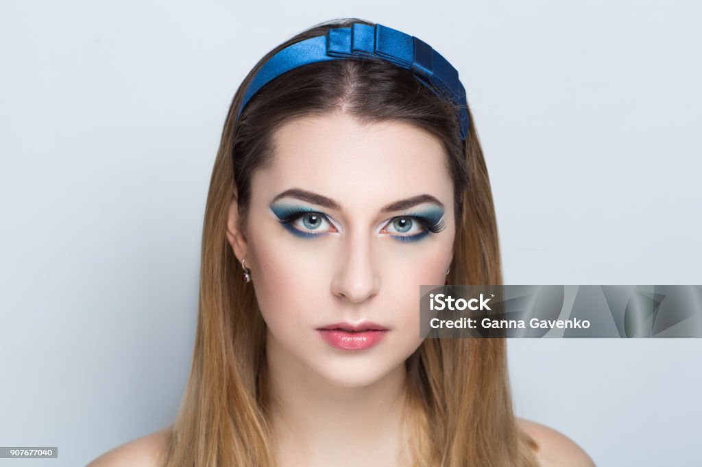 woman beauty face model Closeup portrait of beautiful girl woman lady with combed hair styling. Luxury blue tiara diadem hoop jewelry. Bright shadows makeup, shiny pink lipstick lip gloss. Professional photo model vip person Adult Stock Photo