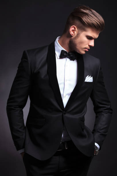 istock business man on black with hands in pockets looks away 907677840